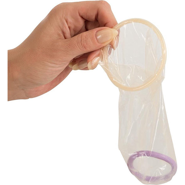 Hand houdt transparant vrouwencondoom vast met zichtbare binnenring en buitenring.