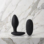 Zwarte We-Vibe Ditto+ buttplug met afstandsbediening op een marmeren plank