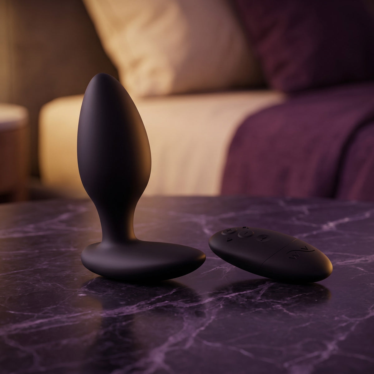 Sfeerbeeld: zwarte Ditto+ buttplug en afstandsbediening op donkerpaars marmer bij gedempt licht
