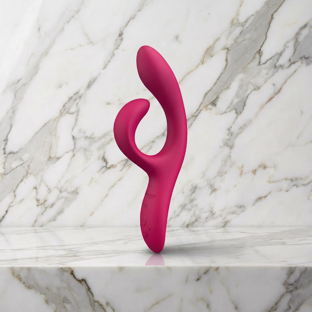 Roze-rode We-Vibe Nova 2 rabbit vibrator rechtop op een marmeren plank