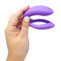 We-Vibe Sync O in hand, toont compact U-vormig ontwerp met bedieningsknoppen