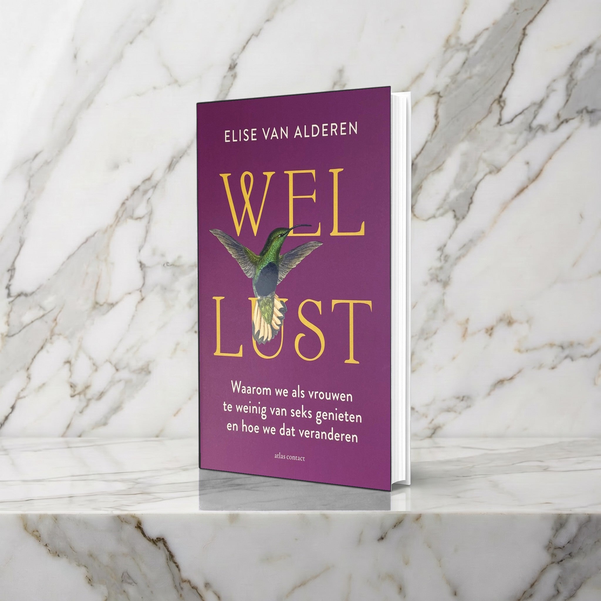 Boek Wellust met paarse omslag en kolibrie rechtop op een marmeren plank, Elise van Alderen