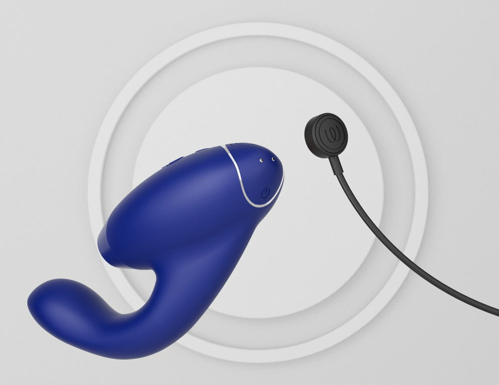 Blauwe Womanizer Duo 2 met de magnetische oplaadkabel op de laadcontacten