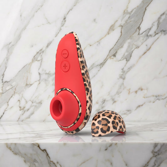 Womanizer Liberty 2 in luipaardprint met het losse kapje op een wit marmeren blad