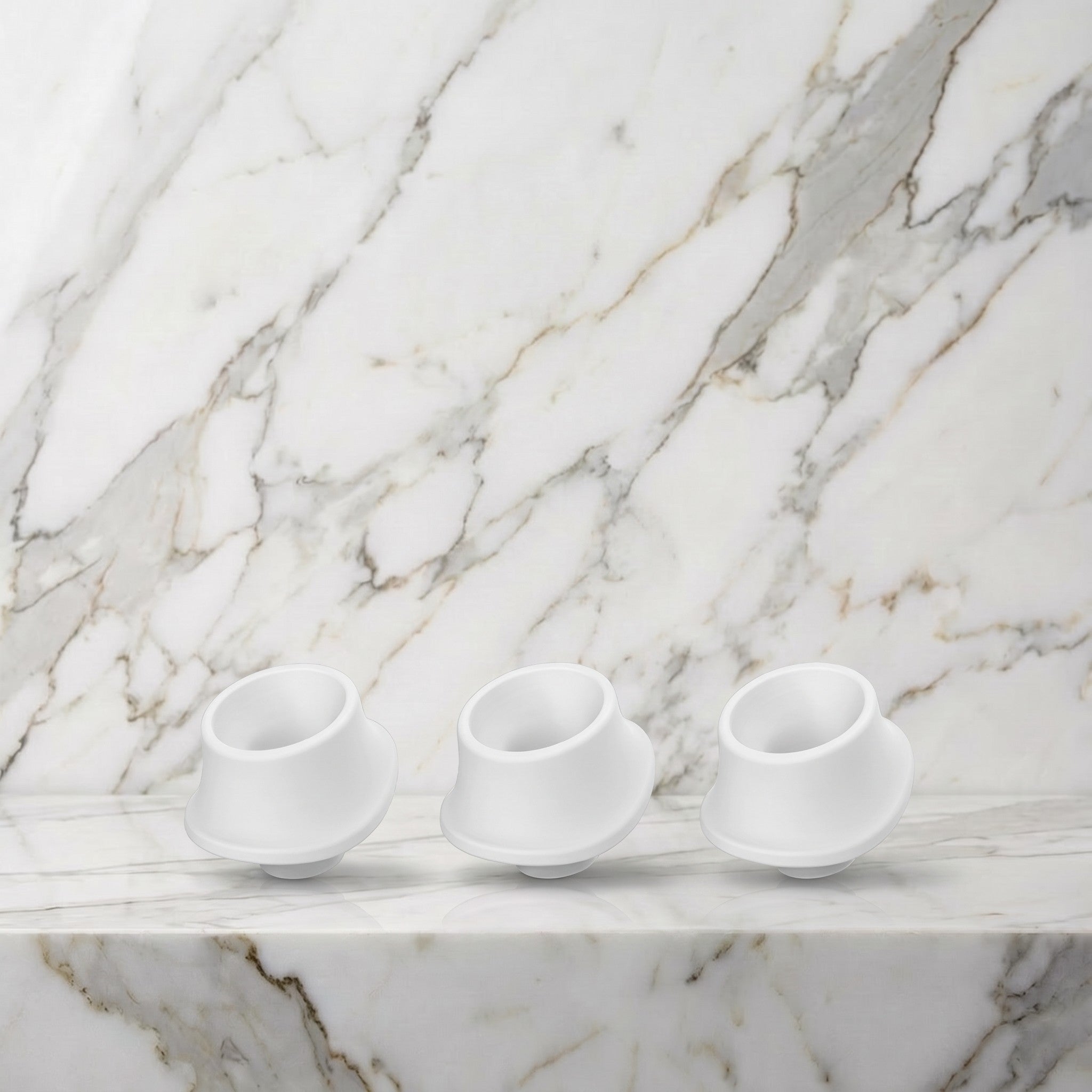 Drie witte siliconen mondkapjes met schuine rand op een marmeren plank, Womanizer
