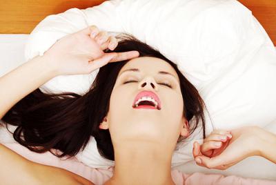 vrouw liggend op bed genietend van orgasme